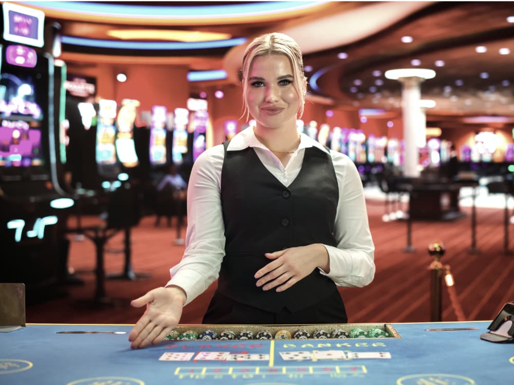 A young woman in a casino at a baccarat table ready to start dealing